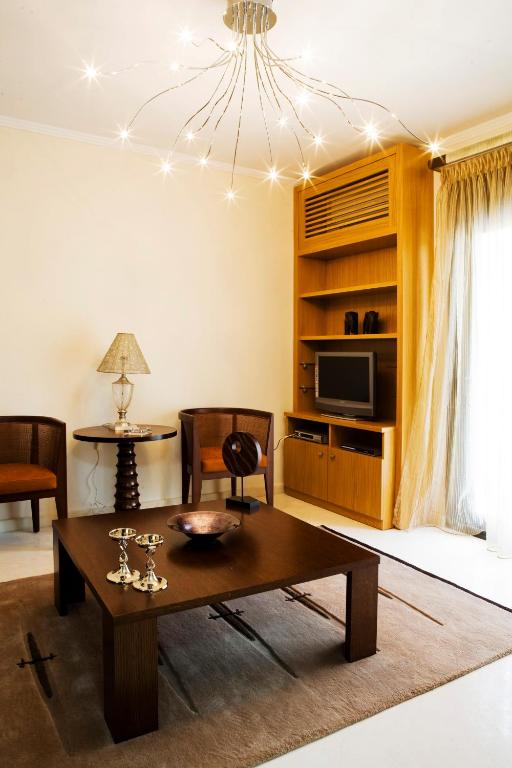 a living room with a coffee table and a chandelier at Melon Suites in Thessaloniki