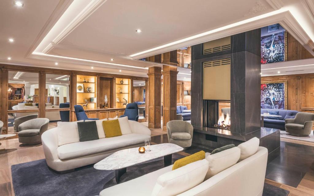 a living room with white furniture and a fireplace at Schlosshotel Ischgl 5-Sterne Superior in Ischgl