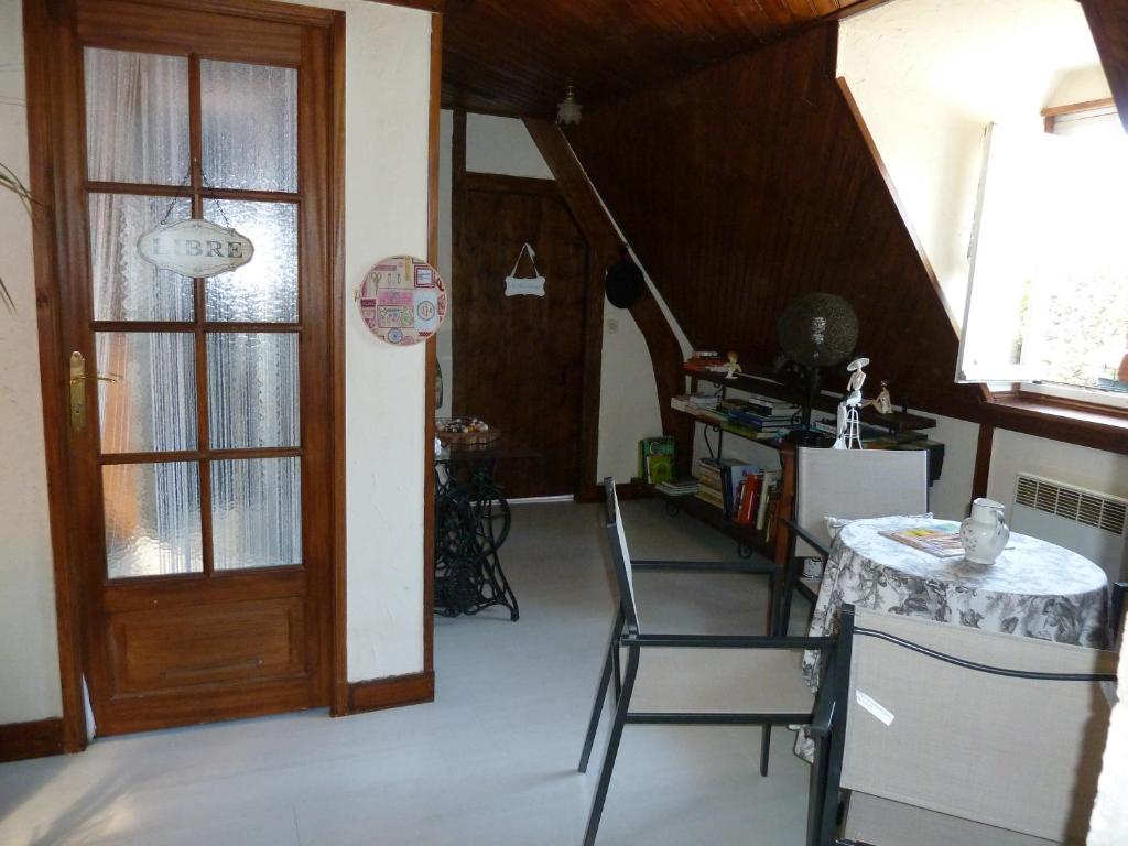 Habitación con mesa, sillas y puerta en Les Alicourts, en Annebault