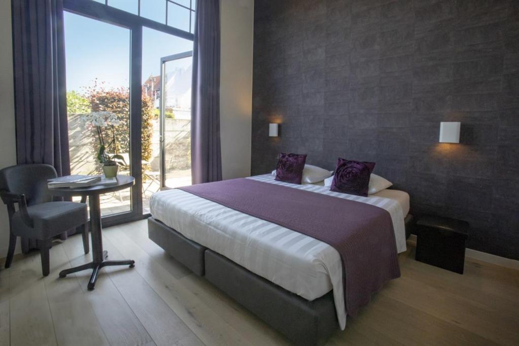 um quarto com uma cama, uma mesa e uma janela em B&B Aurora em Kortrijk