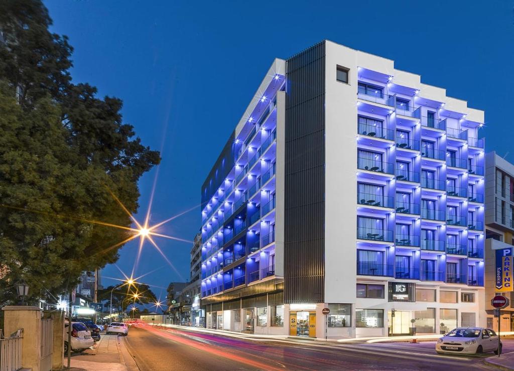 a tall building on a city street at night at Frangiorgio Hotel in Larnaka