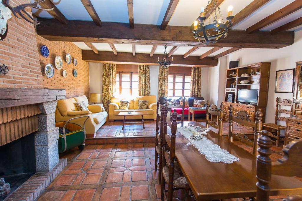 a living room with a table and a fireplace at La Cancela Casa Rural in Fuente el Fresno