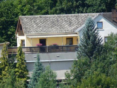 una casa con un balcón con flores. en Ferienhaus Luise, en Sebnitz