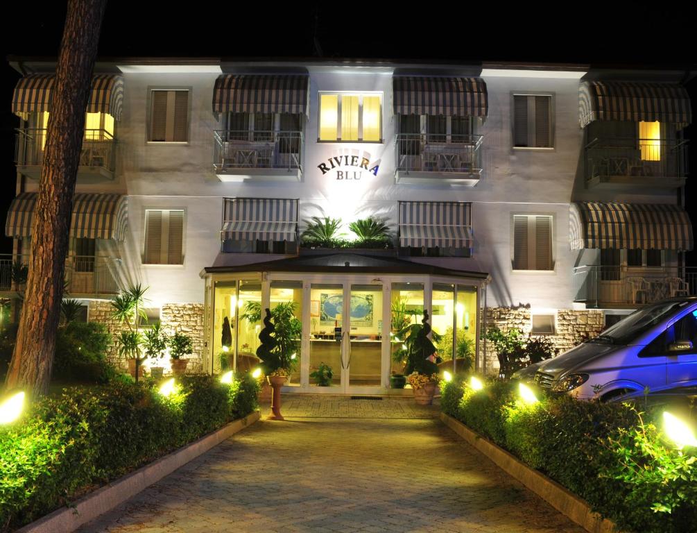a building with a car parked in front of it at Hotel Riviera Blu in Tirrenia