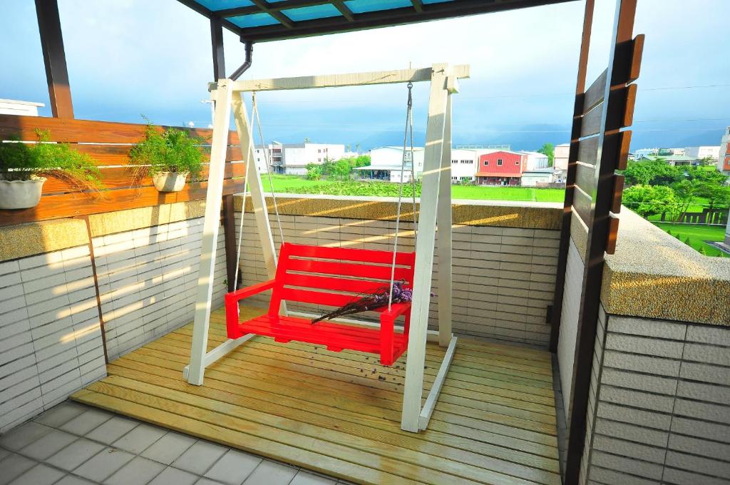 a bird sitting on a swing on a porch at Happy Orange Homestay in Dongshan