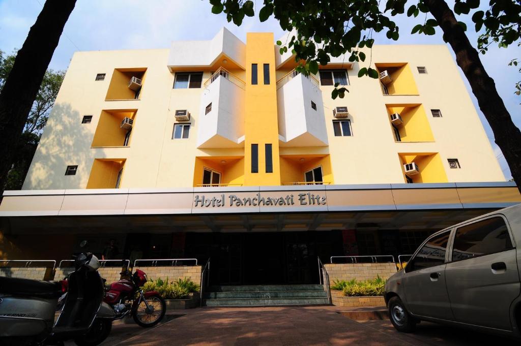 a building with a motorcycle parked in front of it at Panchavati Elite Inn in Nashik