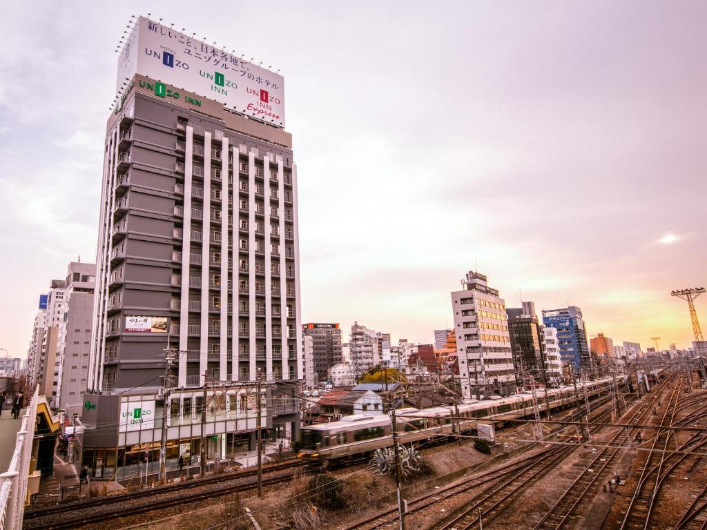 a train is on the tracks in a city at UNIZO INN Shin-Osaka in Osaka