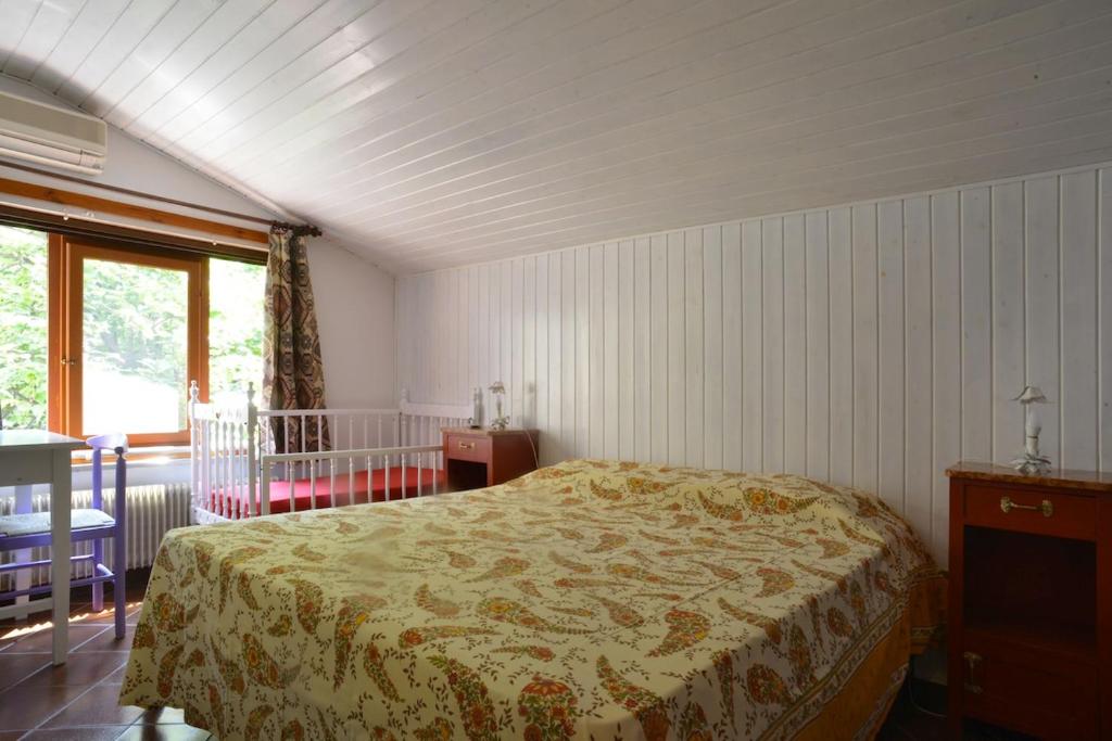 Schlafzimmer mit einem Bett, einem Tisch und einem Fenster in der Unterkunft Casetta Liberty in Grado