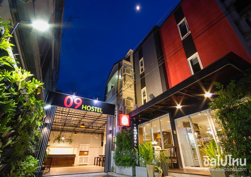 a hotel sign in front of a building at night at 09 Hostel Chiangmai in Chiang Mai