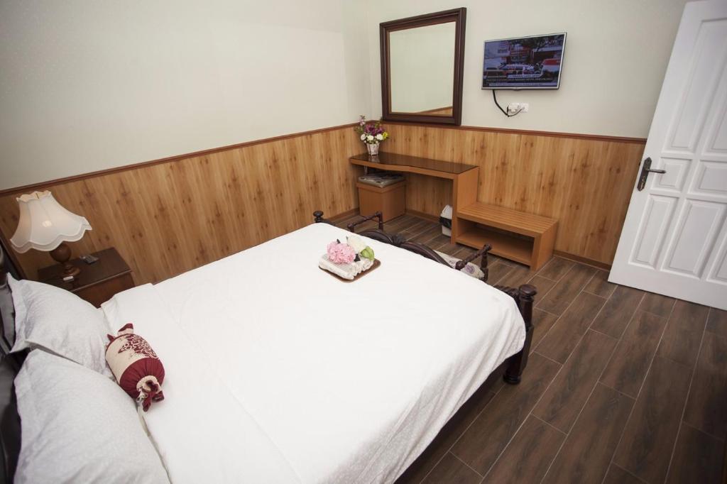 Schlafzimmer mit einem Bett, einem Schreibtisch und einem Spiegel in der Unterkunft Huis Van Gustafine Floor 2 in Malang