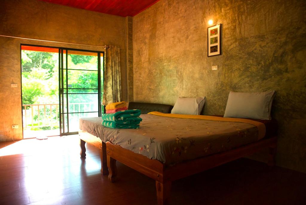 A bed or beds in a room at Maewin Guest House and Resort