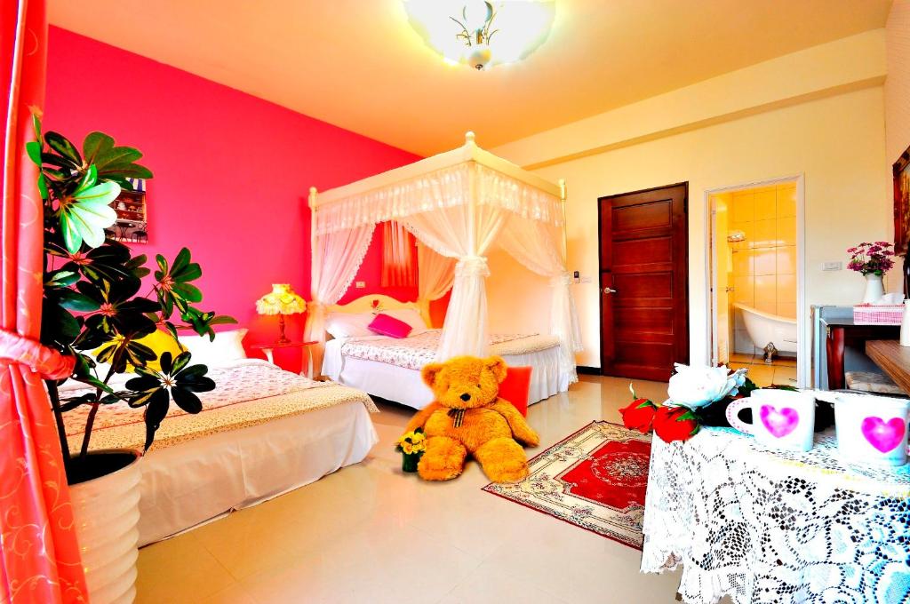 a bedroom with a teddy bear sitting on the floor at Happy Orange Homestay in Dongshan