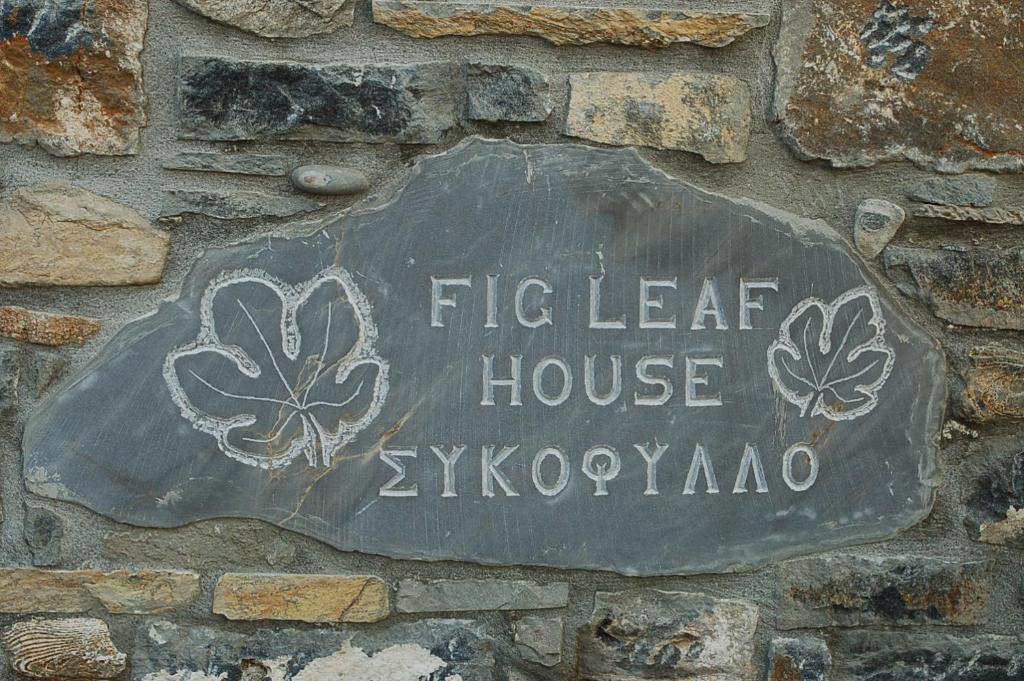 a sign on the side of a building with a flower on it at Fig Leaf House in Elounda
