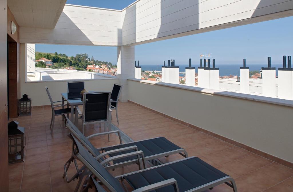 een balkon met stoelen en uitzicht op de oceaan bij Ático con amplia terraza Nautilus II in Luanco