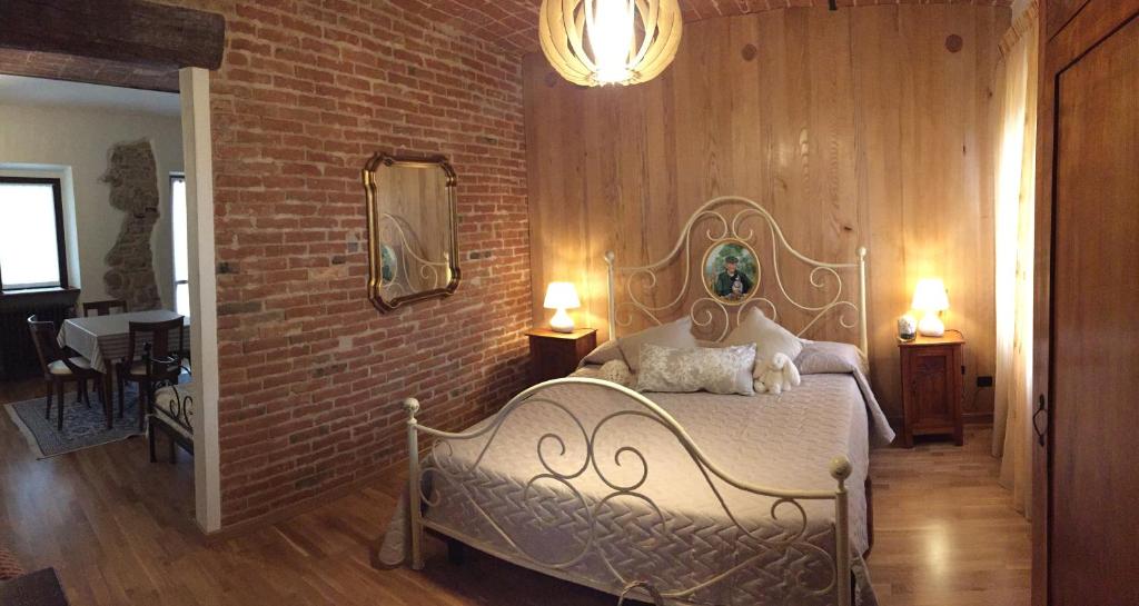 a bedroom with a bed and a brick wall at Cascina Maina in Diano dʼAlba