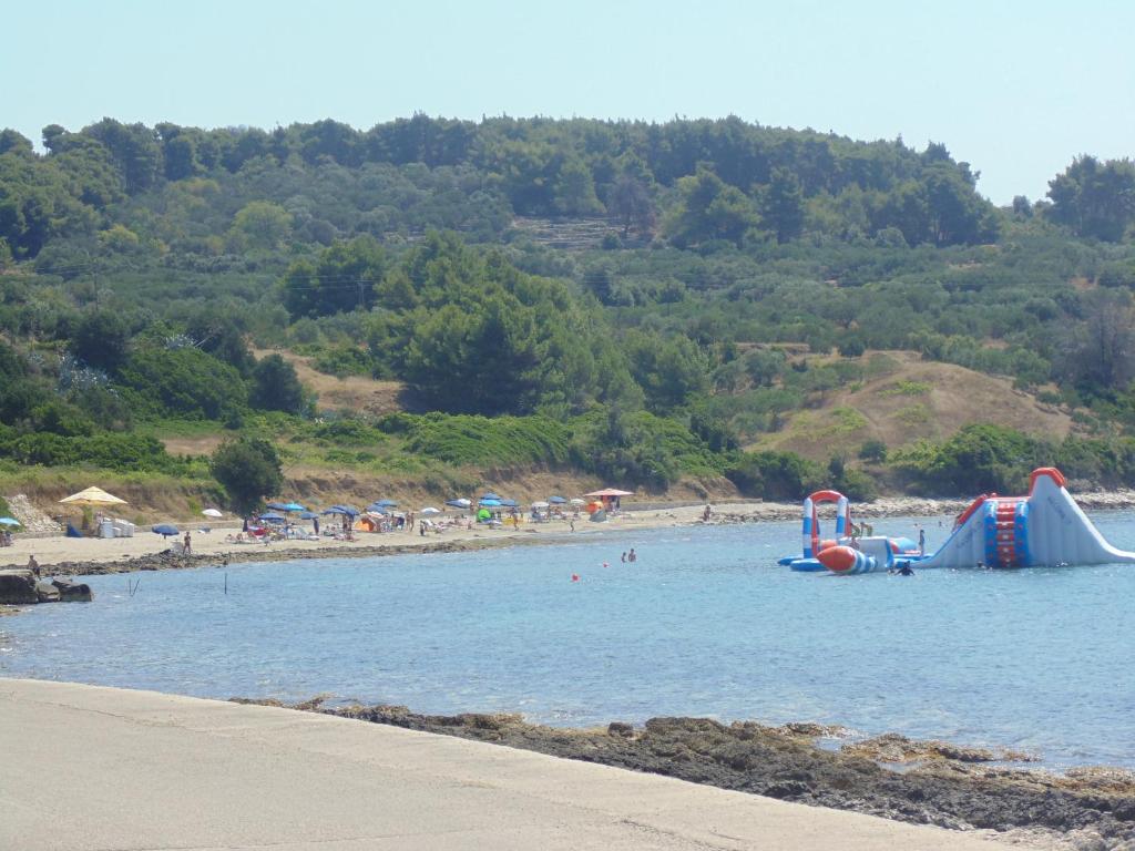 a beach with a water slide in the water at VILLA Apartments Mate Cebalo in Lumbarda