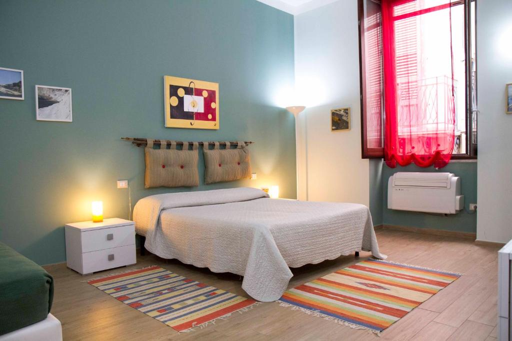 パレルモにあるLe Case Moncadaのベッドルーム1室(ベッド1台付)、赤いカーテン付きの窓が備わります。