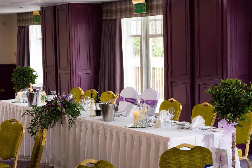 a dining room with white tables and yellow chairs at Leonardo Boutique Huntingtower Perth in Perth