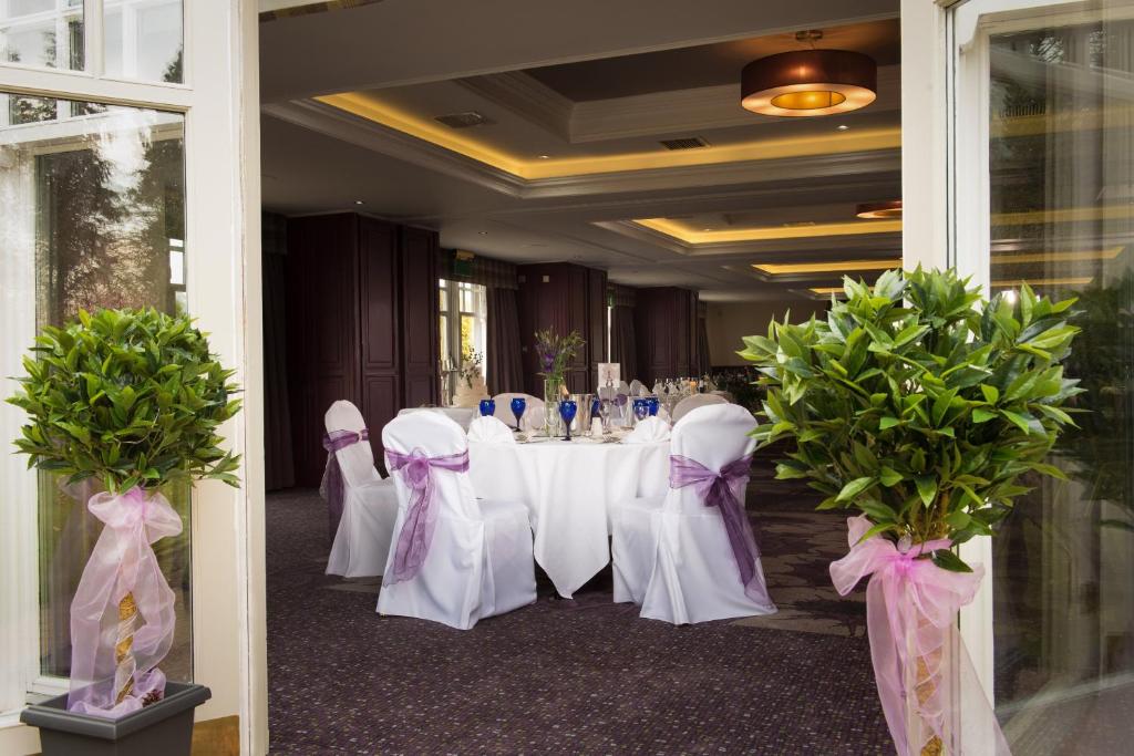 a room with a table with white chairs and purple bows at Leonardo Boutique Huntingtower Perth in Perth