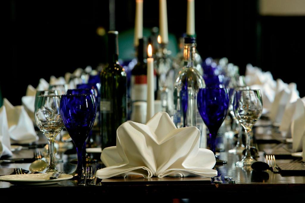 a table with plates and wine glasses and napkins at Leonardo Boutique Huntingtower Perth in Perth