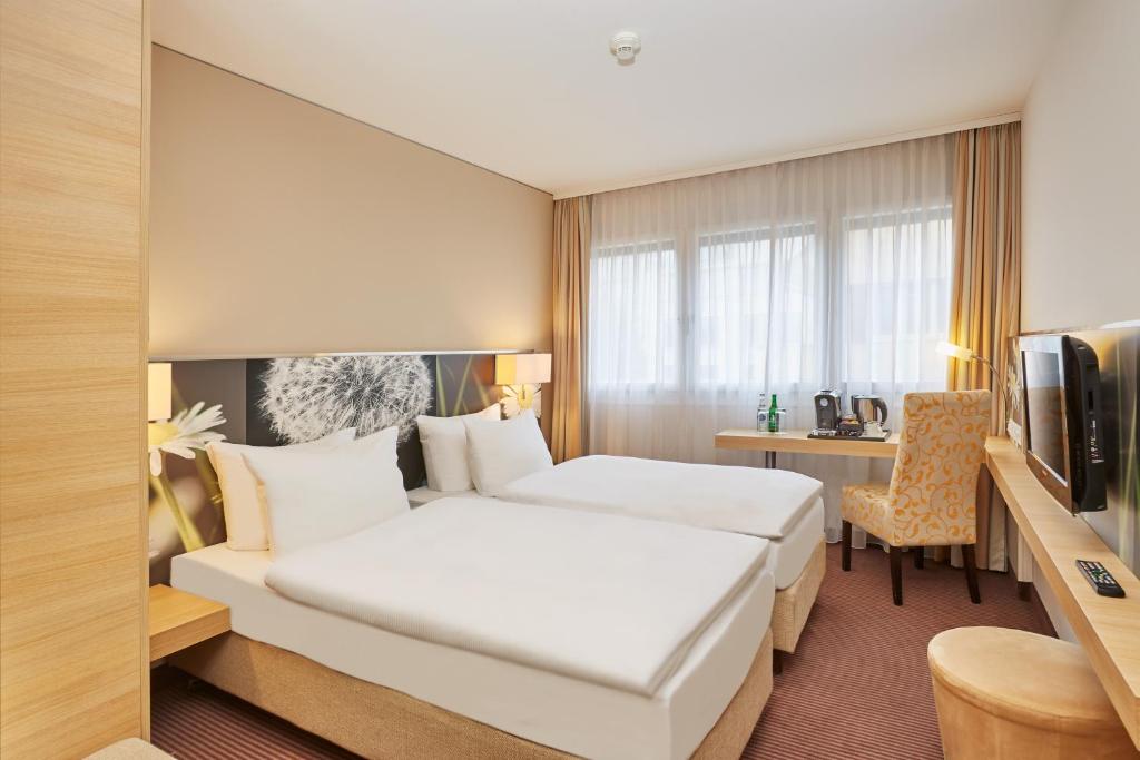 Säng eller sängar i ett rum på H+ Hotel Zürich