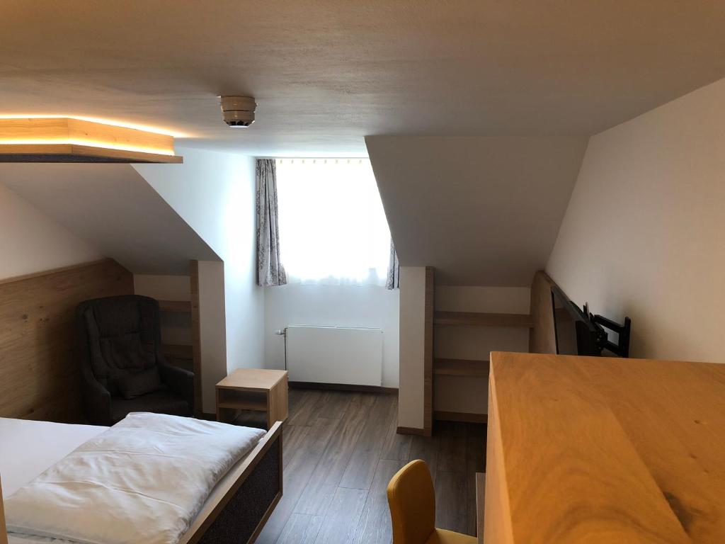 ビューヒルベルクにあるUrlaubshotel Binderのベッド、テーブル、窓が備わる客室です。