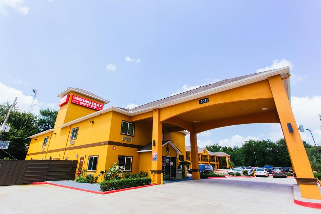 un gran edificio amarillo con una gasolinera en Moonlight Suites - Houston/George Bush Int'l Airport, en Houston