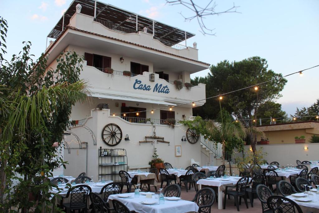 ein Restaurant mit Tischen und Stühlen vor einem Gebäude in der Unterkunft Casa Mita in Pulsano