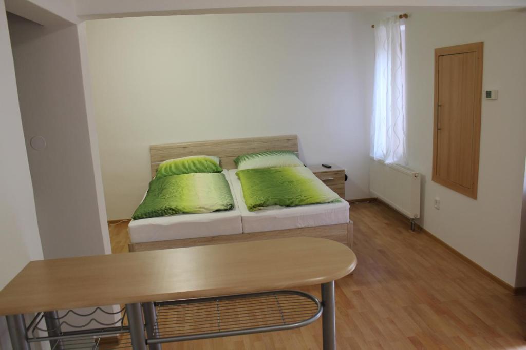 ブルノにあるApartmán 2の緑の枕が付いたソファが備わる客室です。