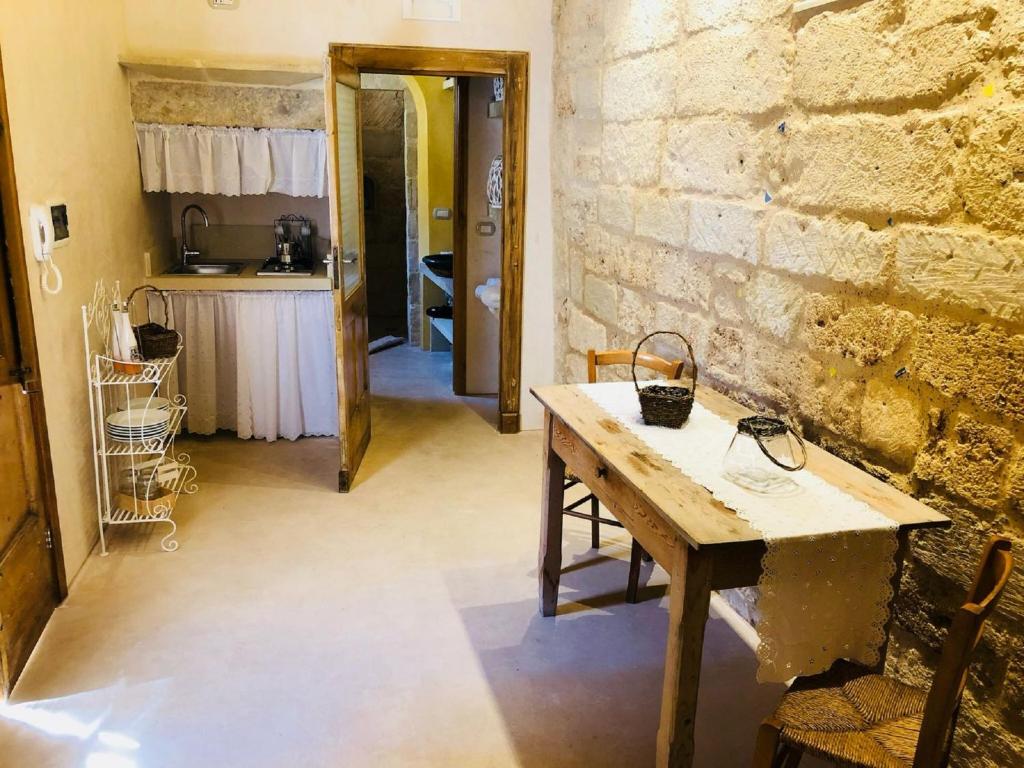 Pokój ze stołem i ceglaną ścianą w obiekcie Borgo in corte w mieście Martano