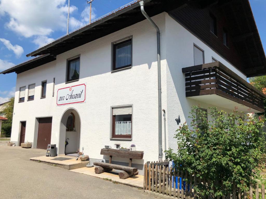 a white building with a bench in front of it at Zur Auszeit in Traunreut