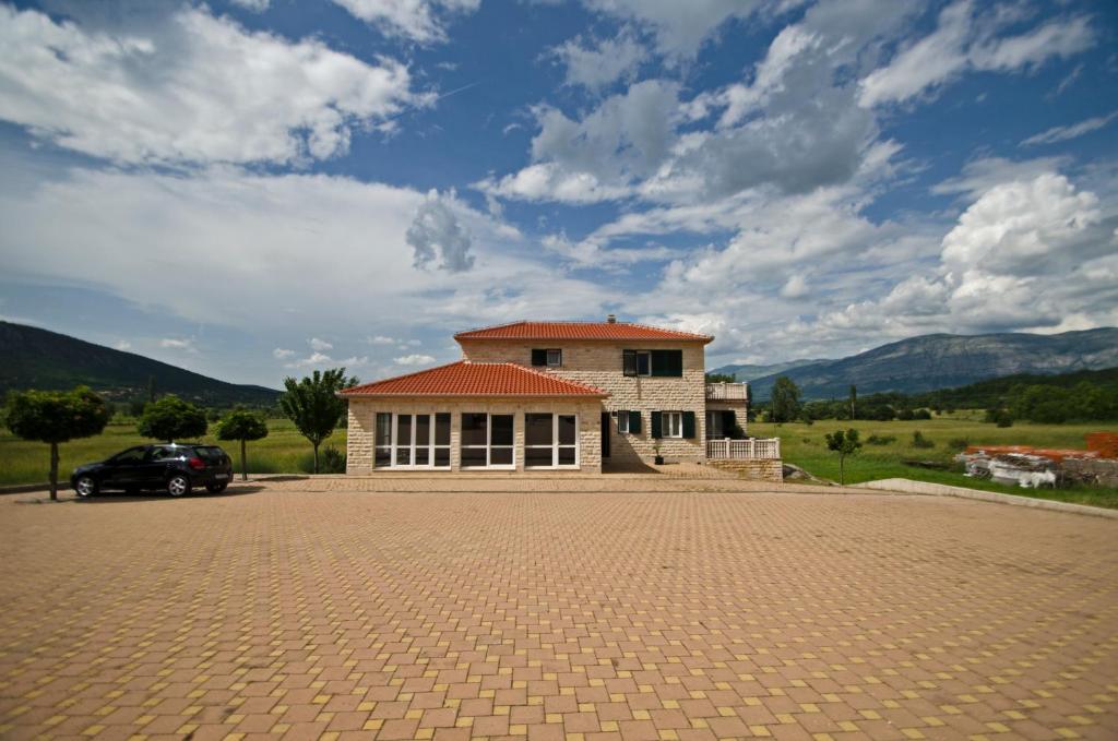 a house with a large driveway in front of it at Rooms Leda in Vrlika