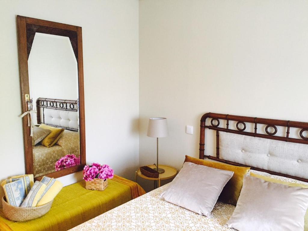 a bedroom with a large mirror and a bed at Casa Máximo in Penafiel