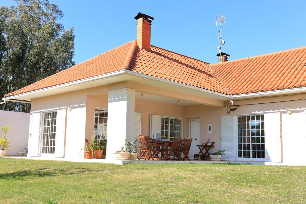 una pequeña casa blanca con techo naranja en Vale Cottage, en Pombal