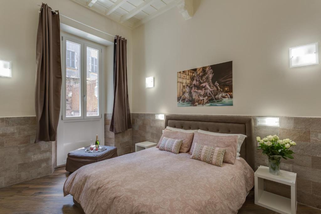 ローマにあるNavona Charme Suiteのベッドルーム1室(ベッド1台付)が備わります。壁には絵画が飾られています。