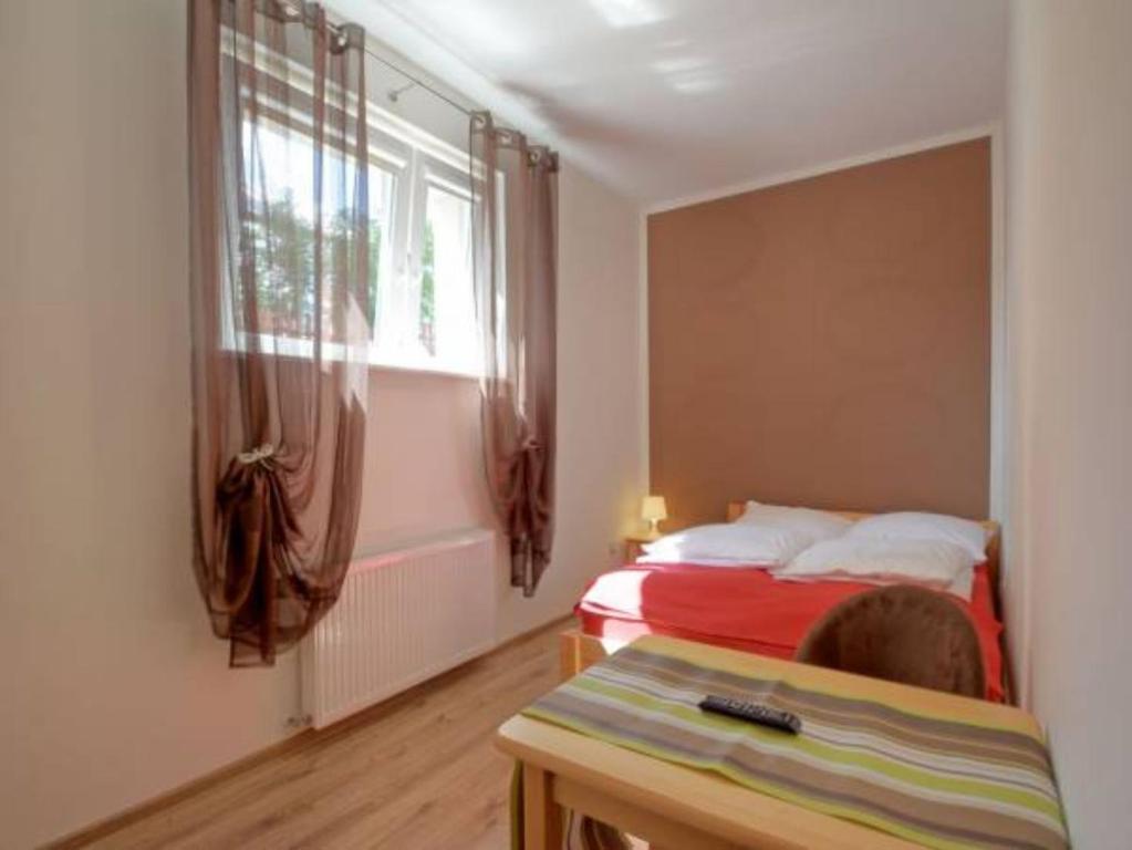 ブワディスワボボにあるMini Apartamenty Dominikaのベッドルーム1室(ベッド1台、窓、テーブル付)