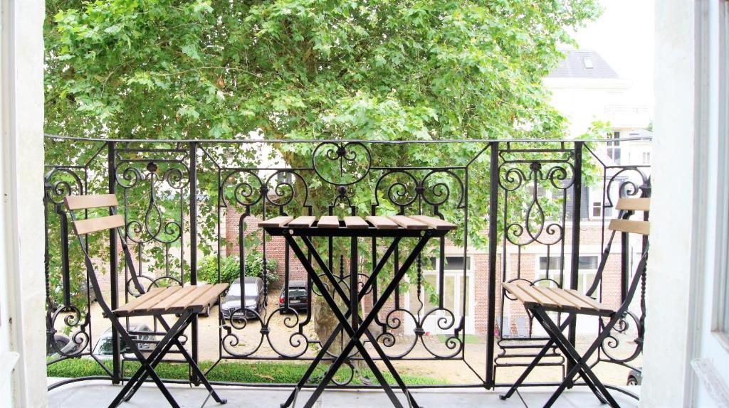 d'une table et de chaises sur un balcon avec une clôture. dans l'établissement Appart Hôtel Lille LOUIS, à Lille