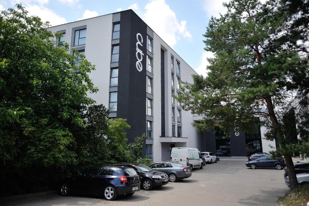 a building with cars parked in a parking lot at Cube Apartamenty in Lublin