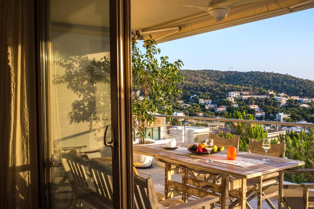 uma mesa numa varanda com vista para a cidade em Modern Apartment with sea view in Saronida em Anavissos