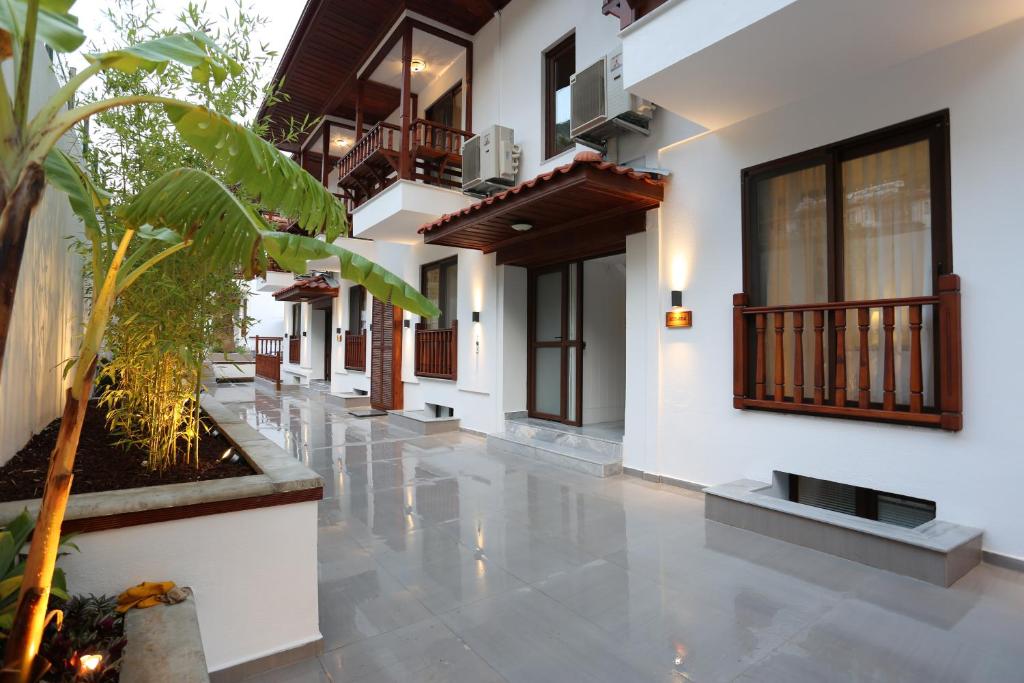 a corridor of a house with a courtyard with plants at Alp Suites Pinehill in Akyaka