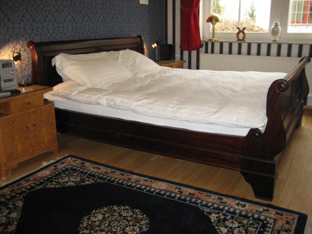 a bedroom with a bed with a wooden frame at Leibniz6 Stilvolles Privatzimmer in Leipzig