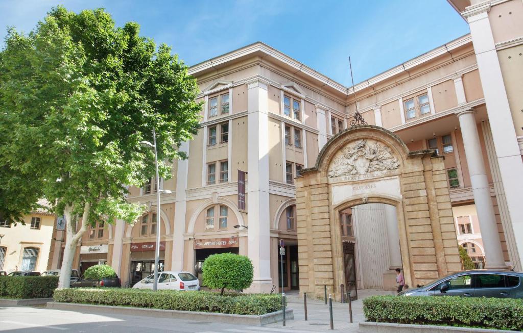 un edificio con coches estacionados frente a él en Odalys City Aix en Provence L'Atrium, en Aix-en-Provence