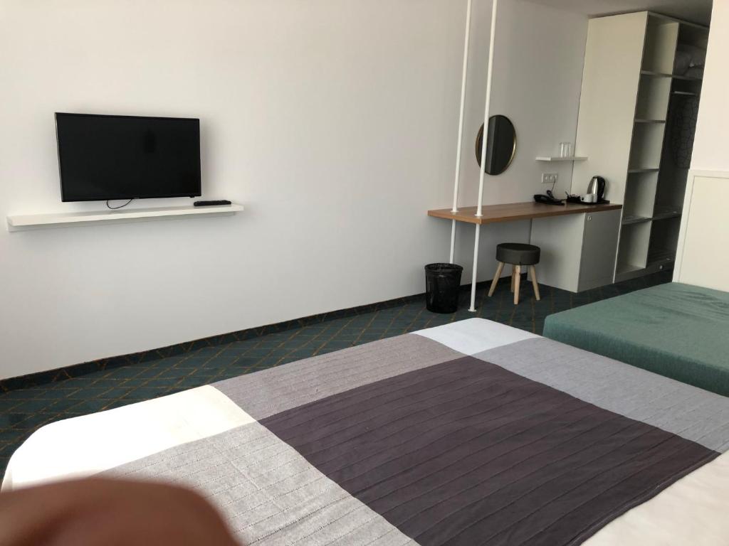 a hotel room with a bed and a flat screen tv at Sunrise Blue Magic Resort - All Inclusive in Obzor