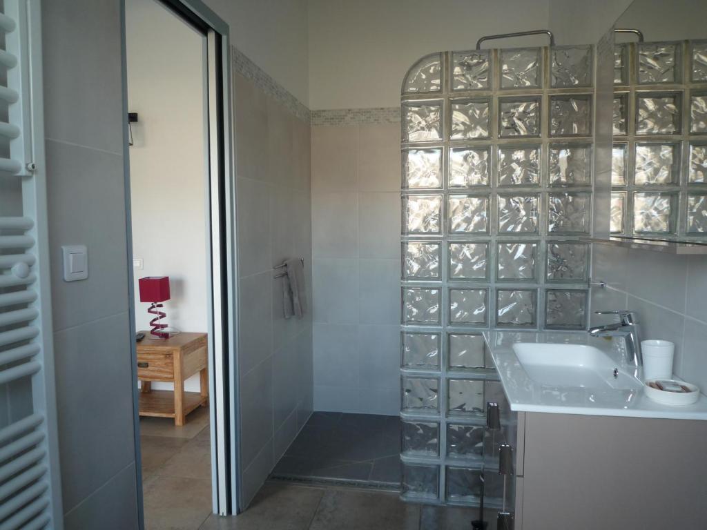 a bathroom with a sink and a shower with glass doors at Chambres d&#39;hôtes - Chez Stephane in L&#39;Ile d&#39;Yeu
