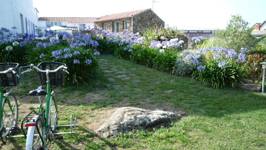 a bike parked next to a garden of flowers at Chambres d&#39;hôtes - Chez Stephane in L&#39;Ile d&#39;Yeu