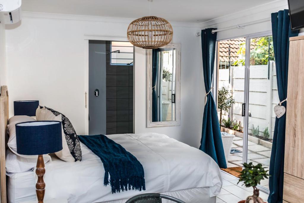 ein Schlafzimmer mit einem Bett mit einer blauen Decke darauf in der Unterkunft The Studio on Balmoral in Durban
