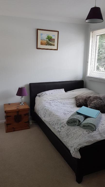 1 dormitorio con 1 cama con ordenador portátil en Quiet house beside Stansted Airport, en Bishops Stortford