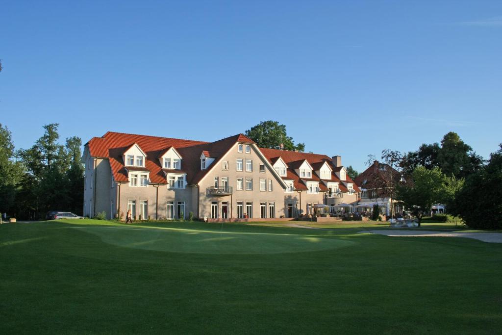 a large house on a golf course with a green at Ahauser Land & Golfhotel in Alstätte