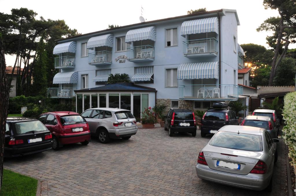 a parking lot with cars parked in front of a building at Hotel Riviera Blu in Tirrenia