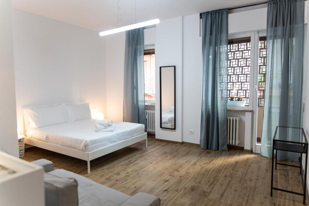 a white bedroom with a bed and a window at Dora’s Room in Pescara